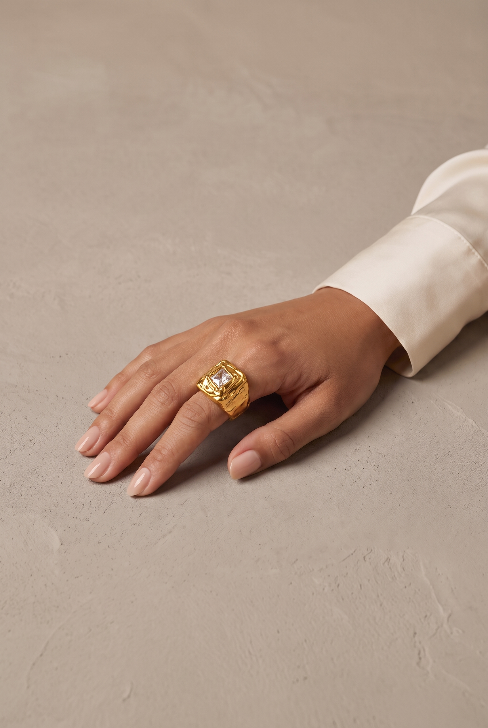 Molten square signet ring in gold worn on the hand
